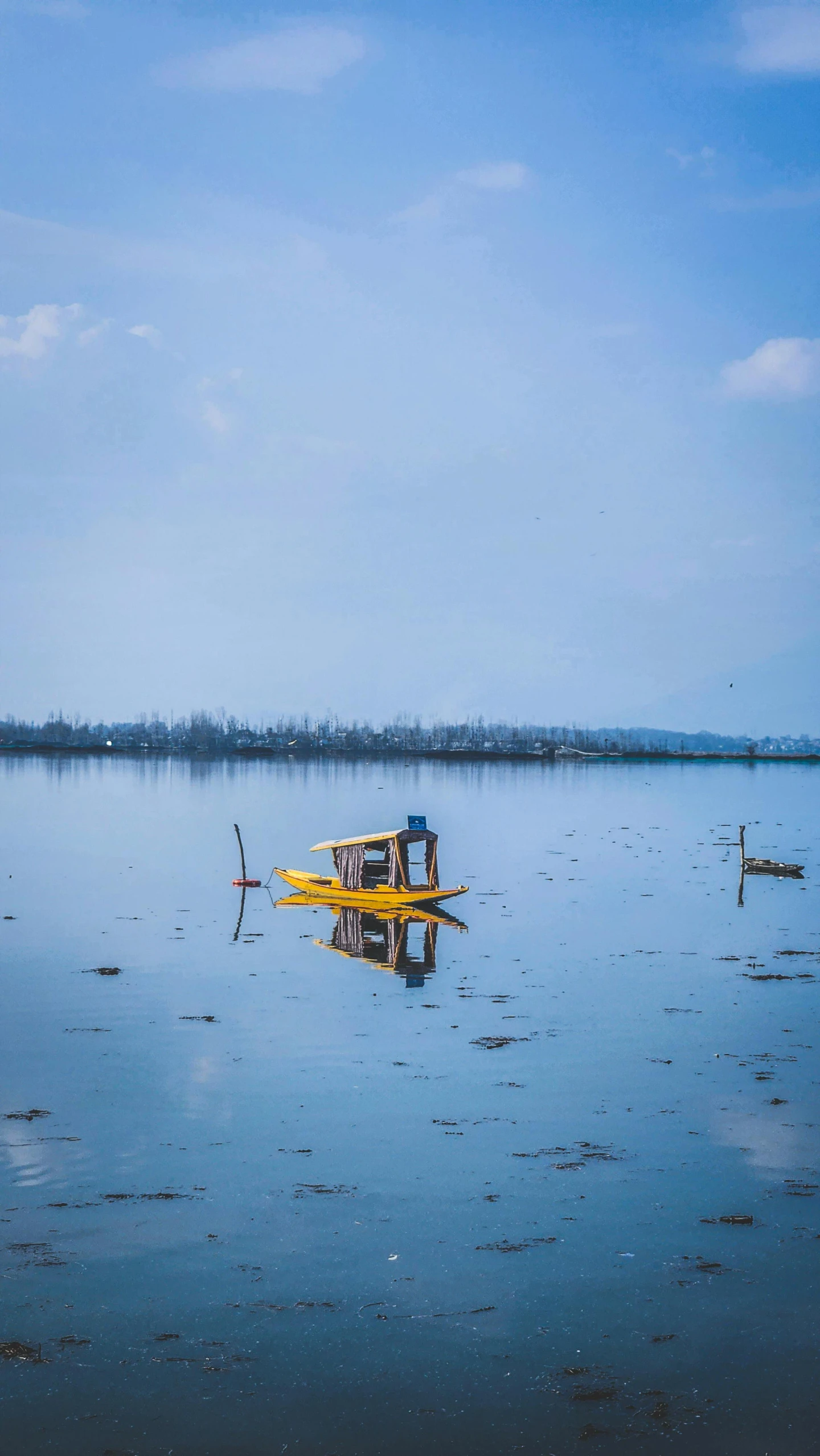 a yellow boat with a bench on the top in the middle of some water