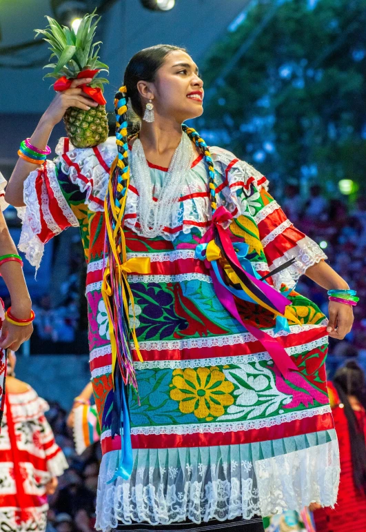 a beautiful young woman wearing a pineapple in a colorful dress