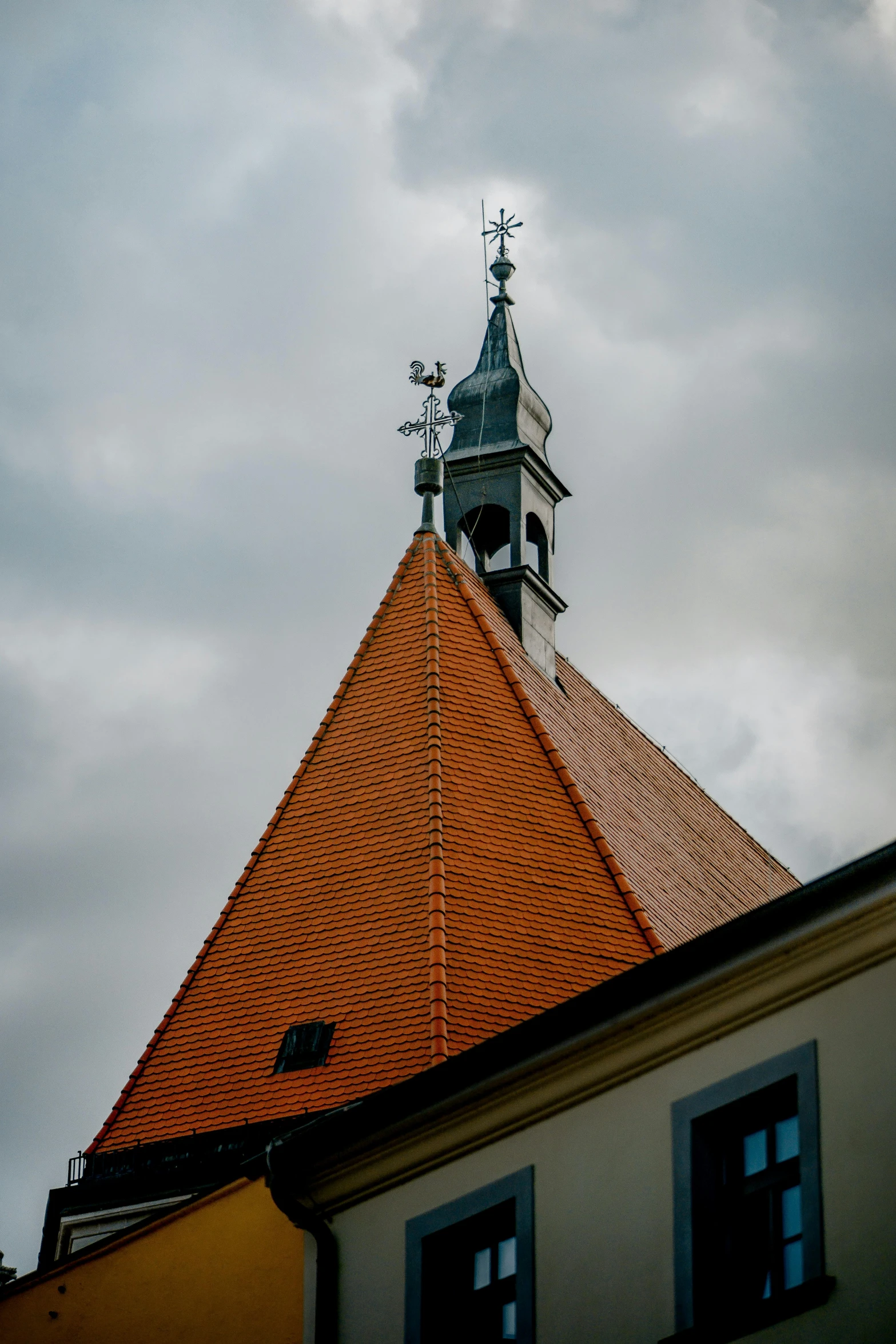 view from below of steeple with weather vane and roof