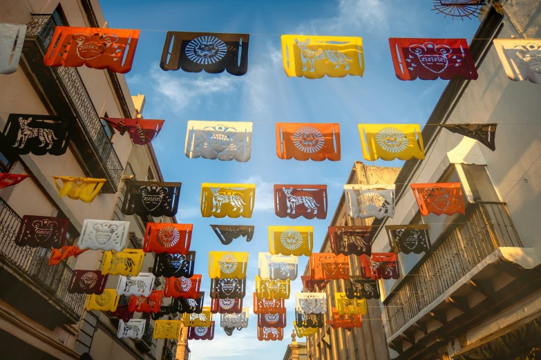 multicolored flags and decorative signs hang in the middle of an outdoor area