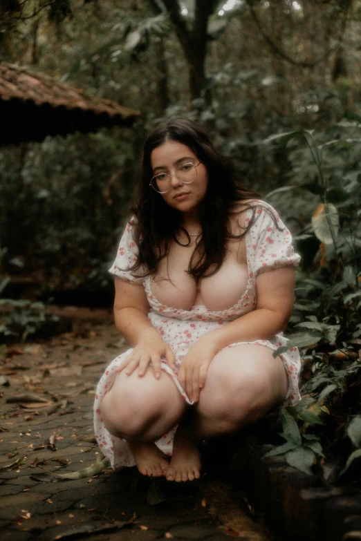 a woman in glasses sitting in the woods