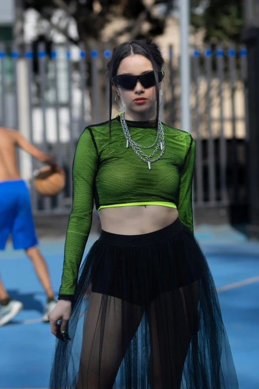 a woman wearing a long skirt while standing on a court