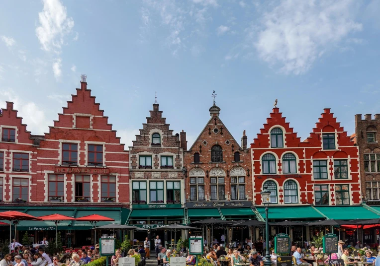 many buildings on the side of a street with people walking