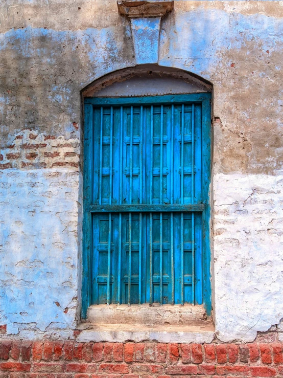 an old blue building with two wooden doors