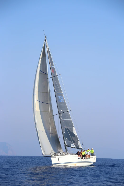 the sailing vessel is white with black sail