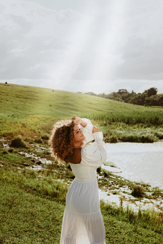 a woman is dressed in a white dress and standing outside