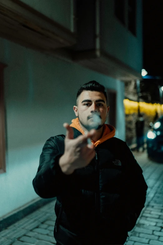 a man smoking a cigarette outside on a brick street