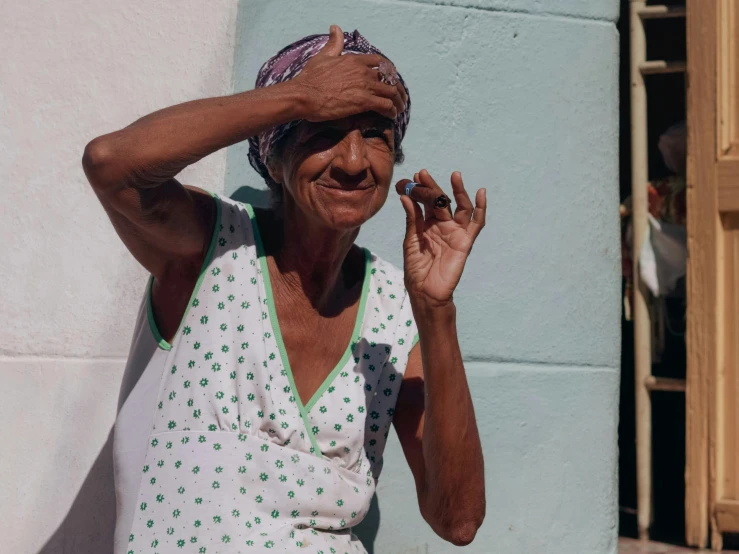 an older lady poses on the street holding her hand over her head