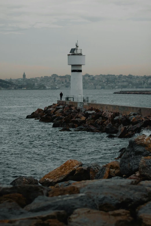 a light house sits on a rocky shore