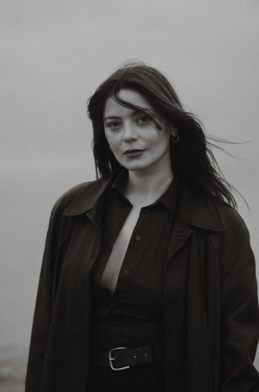 a woman posing with her shirt on in black and white