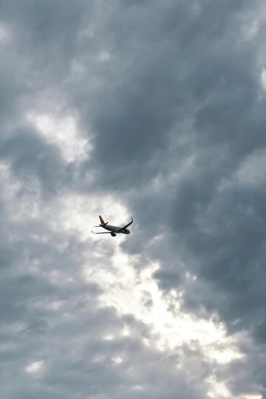a plane flies by a cloudy sky with clouds