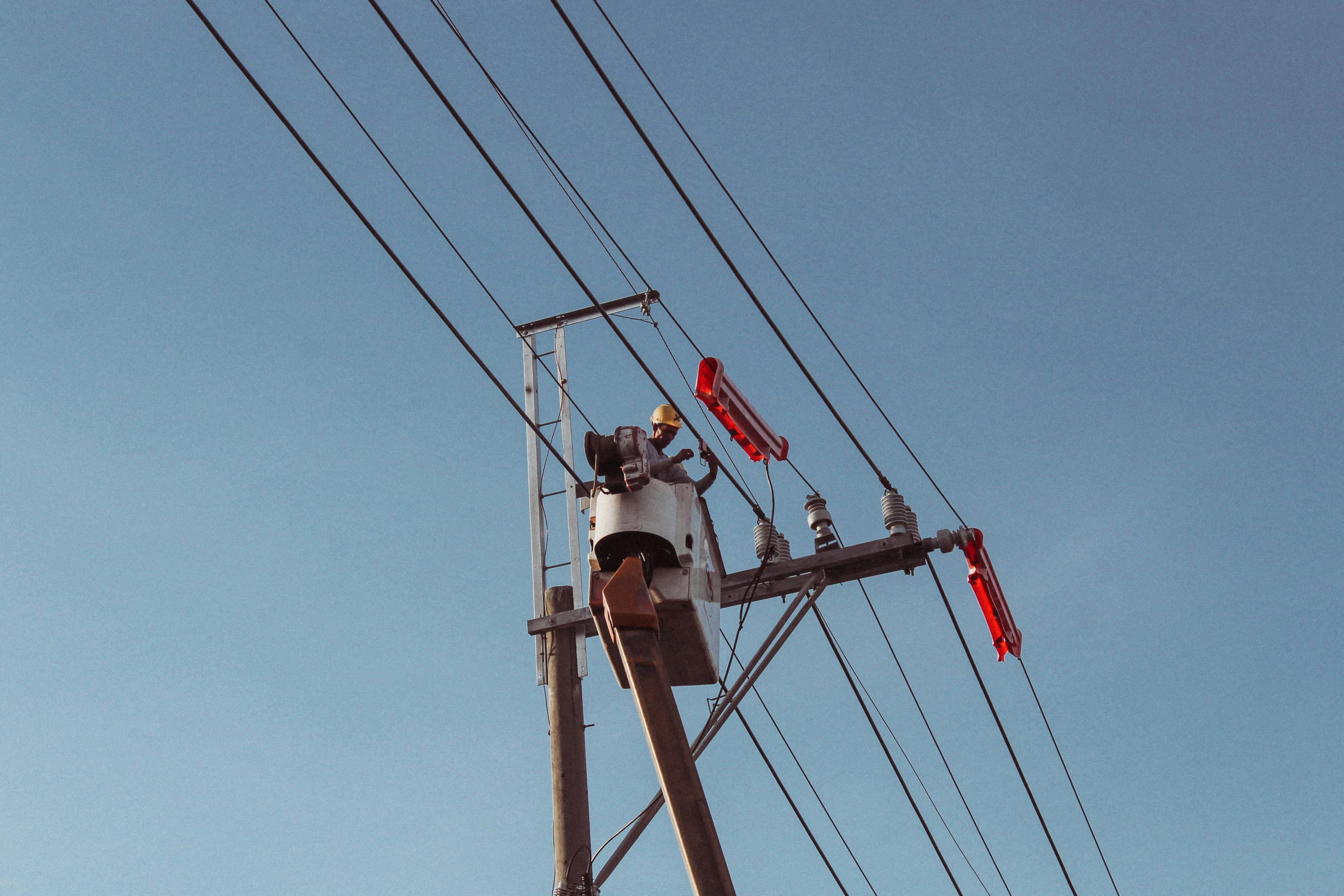 a man is fixing some power lines and it looks like he is trying to fix it