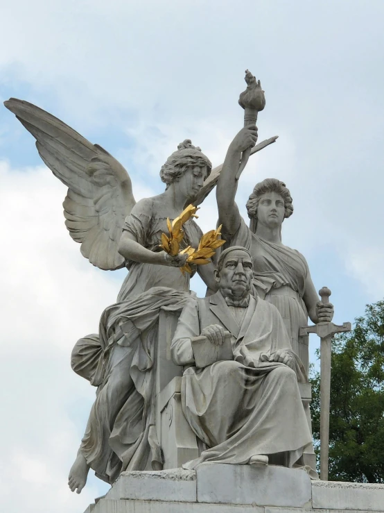 statue of an angel holding a lamp between two men