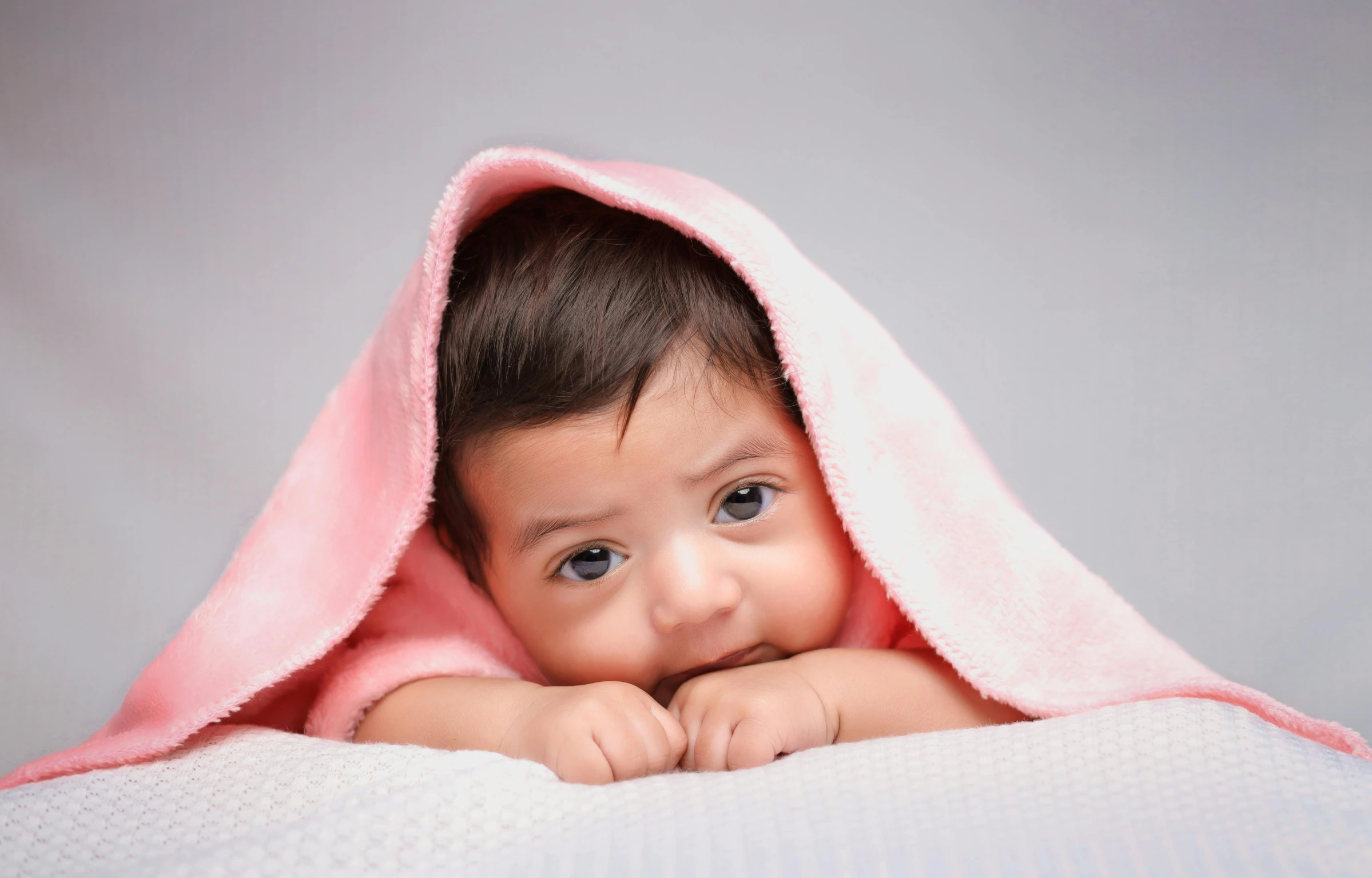 a baby is laying on top of a blanket with his arms around his back