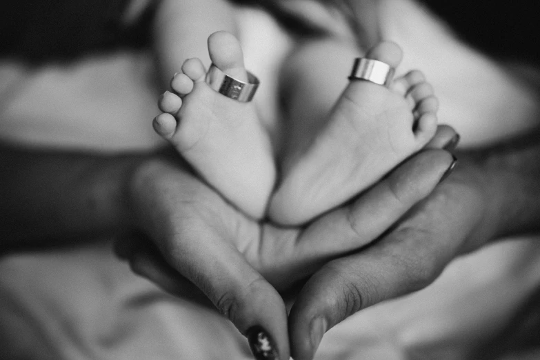 a person holding their baby's toes in front of their hands