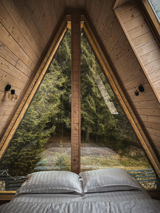 a bedroom with an opening to the woods, and wooden walls