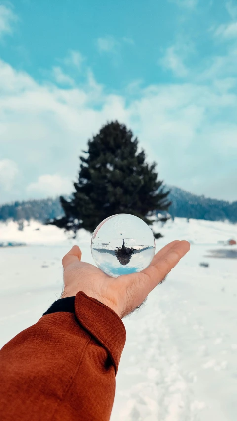a person holding a ball of snow up in the air