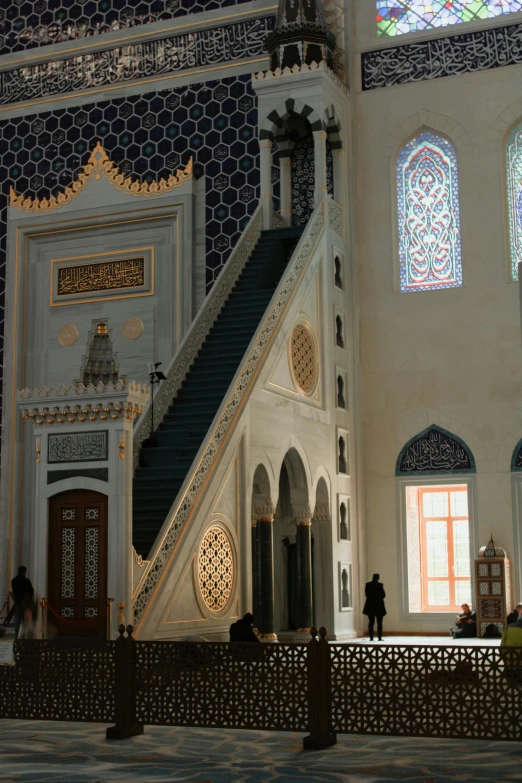 stairs in a room with three windows and mosaic designs