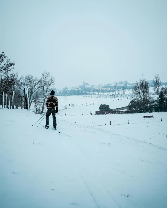 man skiing across large open snow covered field