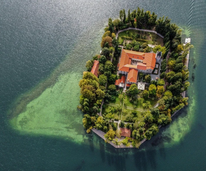 an island with lots of trees and some grass