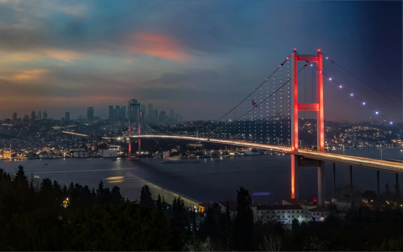 the large bridge is lit up at night