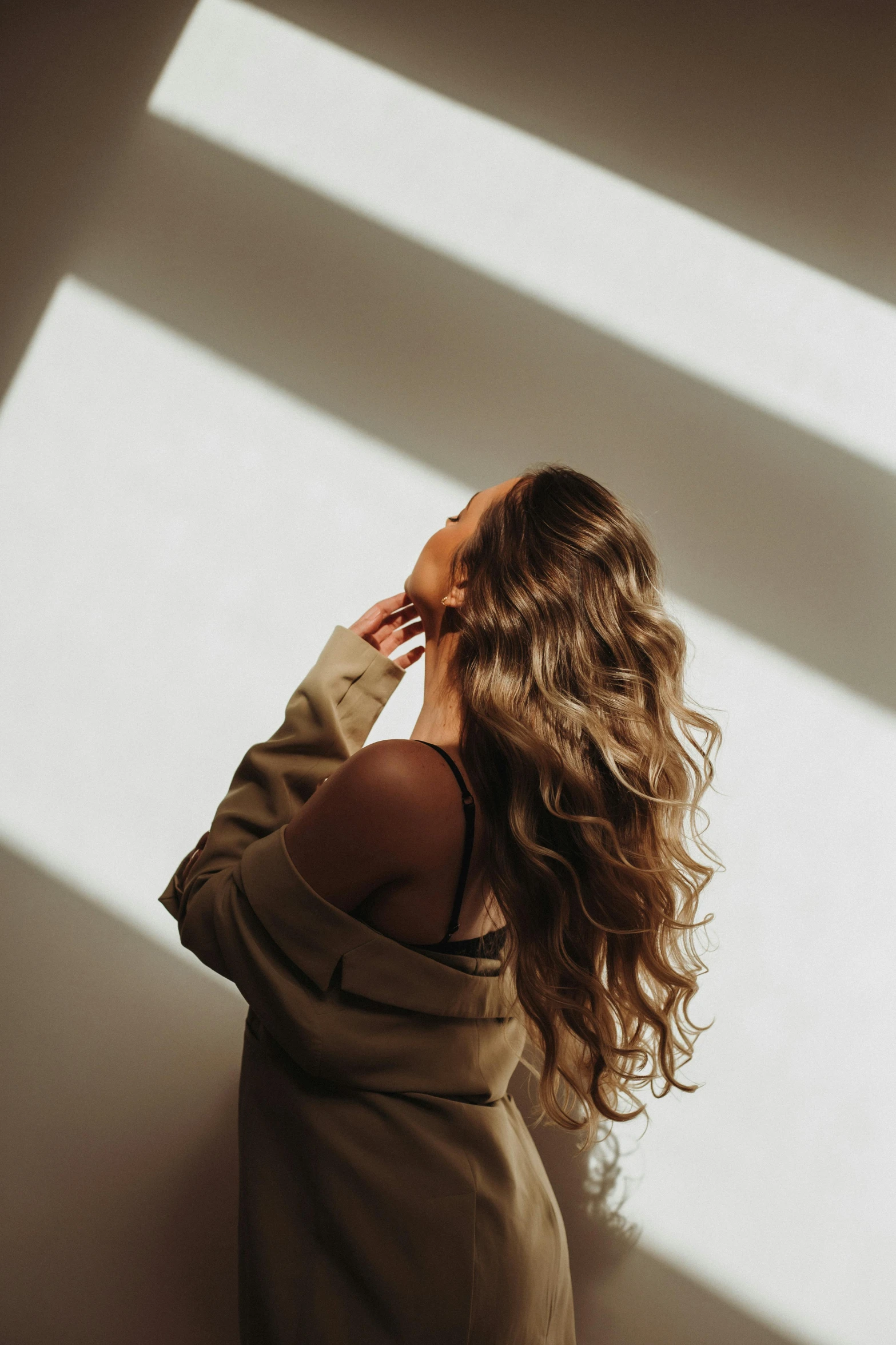 a woman walking in the sun, looking out the window