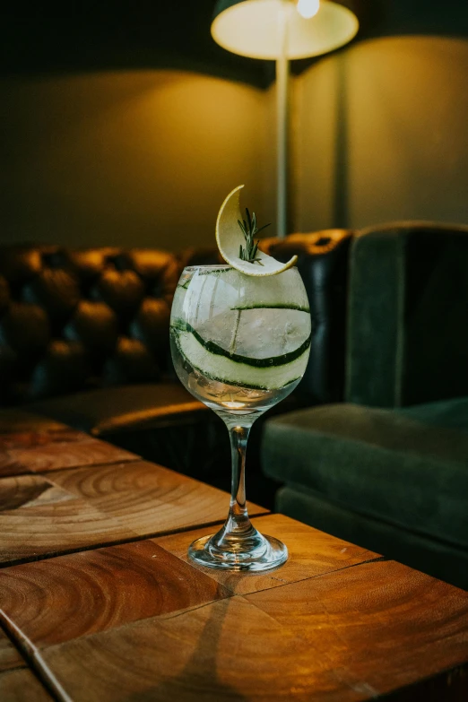 an alcoholic drink with ice and an apple sitting on top of a table