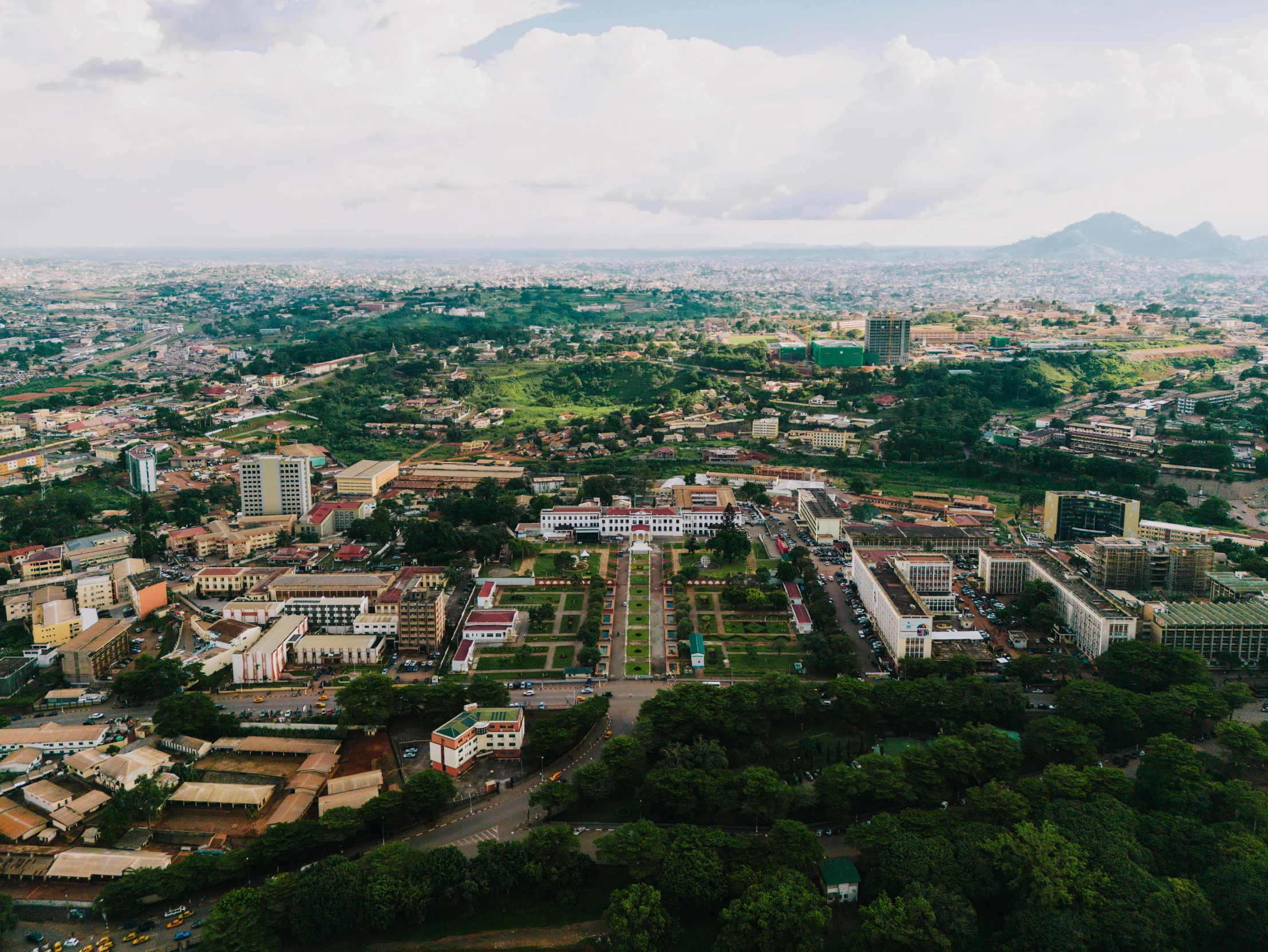 an aerial view of an outdoor cityscape area with mountains in the background