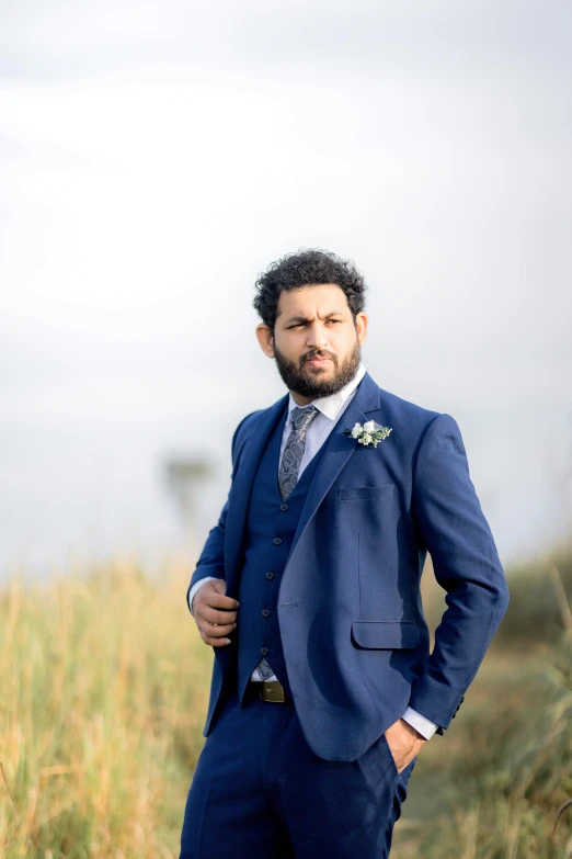 a man wearing a blue suit with a flower in his lapel