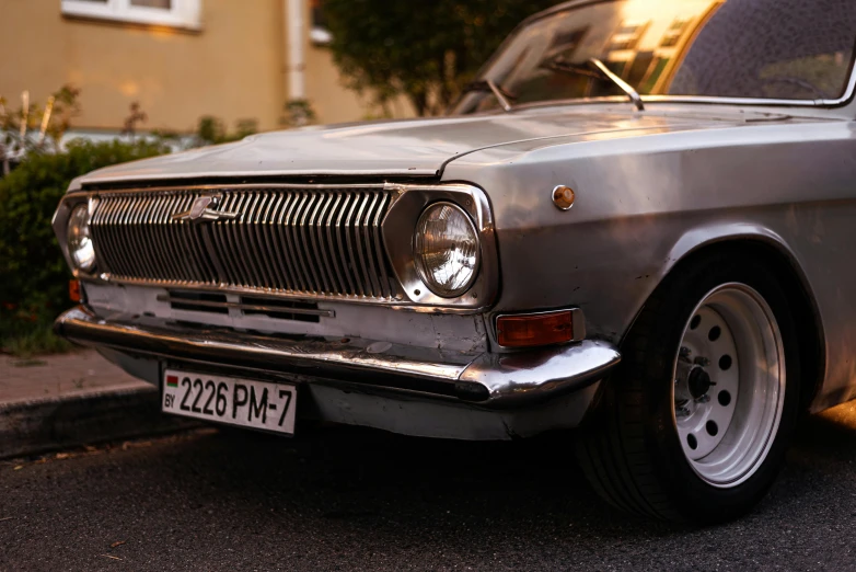 a rusty car with chrome grilles parked on the street