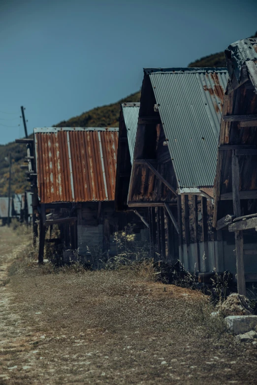 a couple of wooden buildings in the dirt