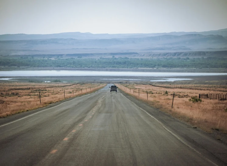 a road with a small truck driving down it