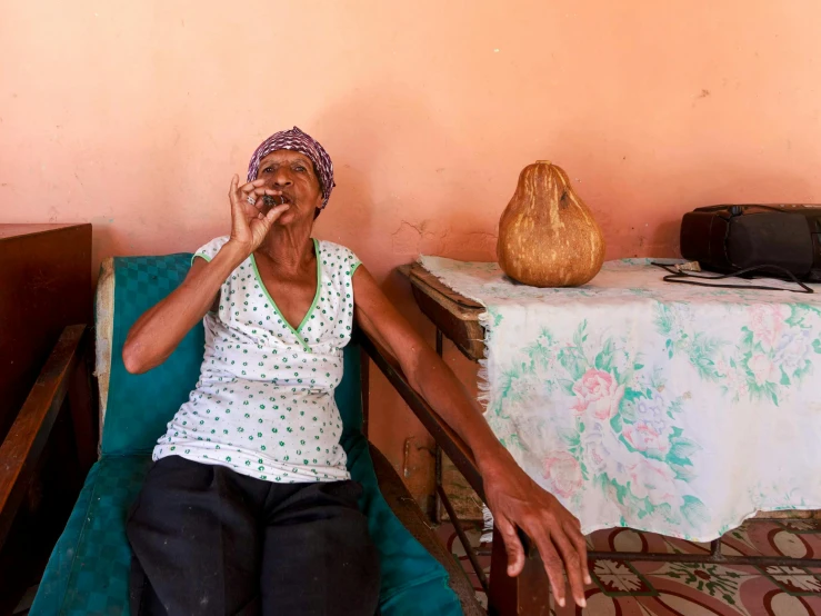 a woman sitting on top of a bench holding her nose