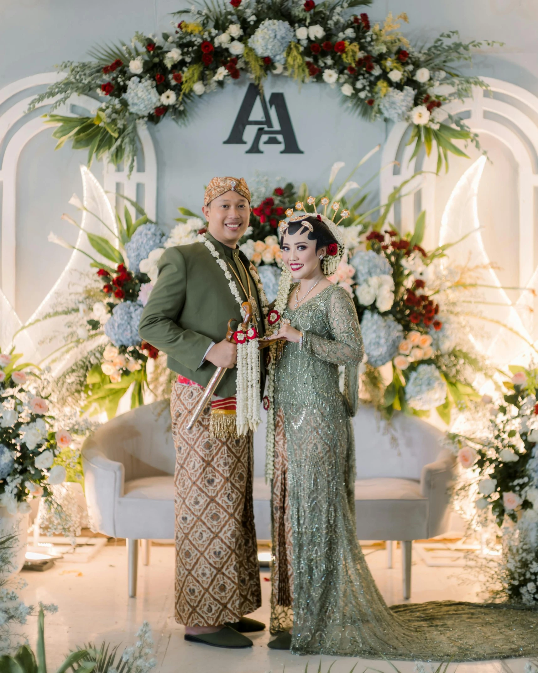 two people posing for a po in front of a floral backdrop