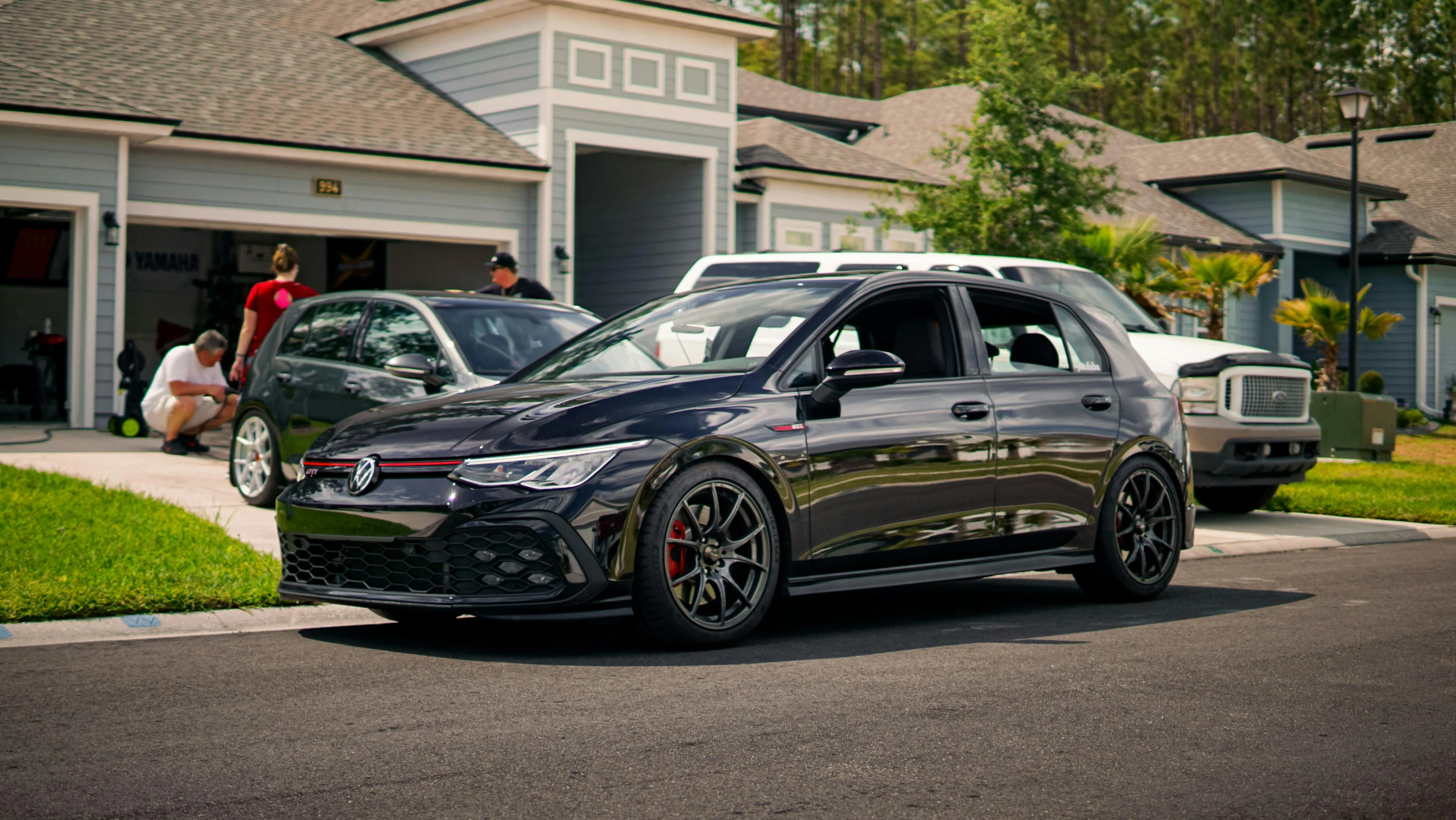 a grey car is parked in front of a few houses