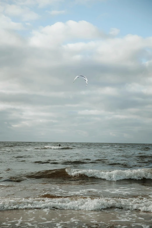 a white kite is flying over the ocean