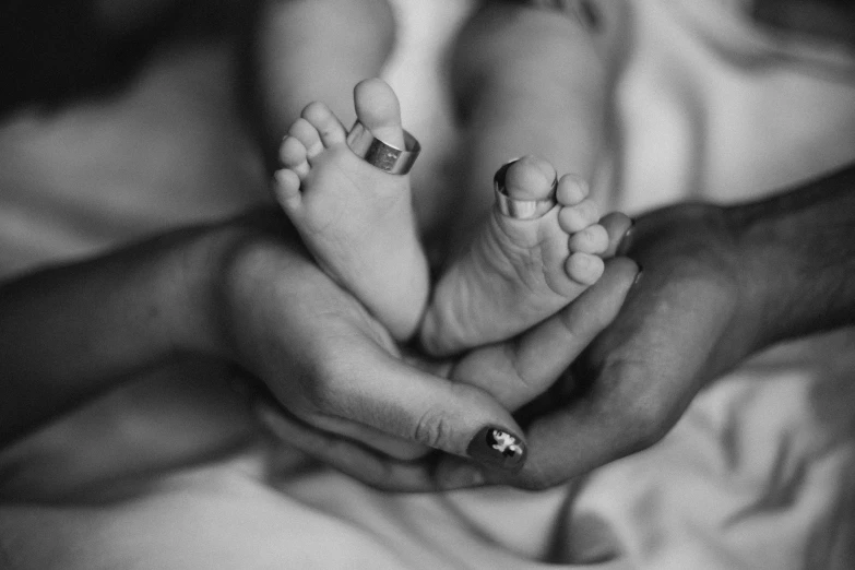 a couple holding their baby on top of a bed