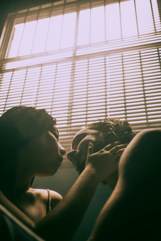 two women are sitting together by a window