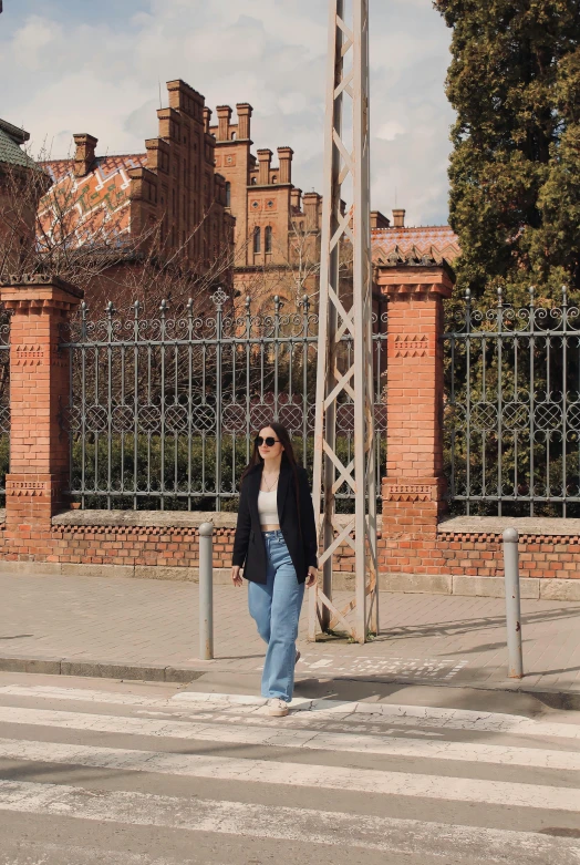 a woman in sunglasses walks on the street