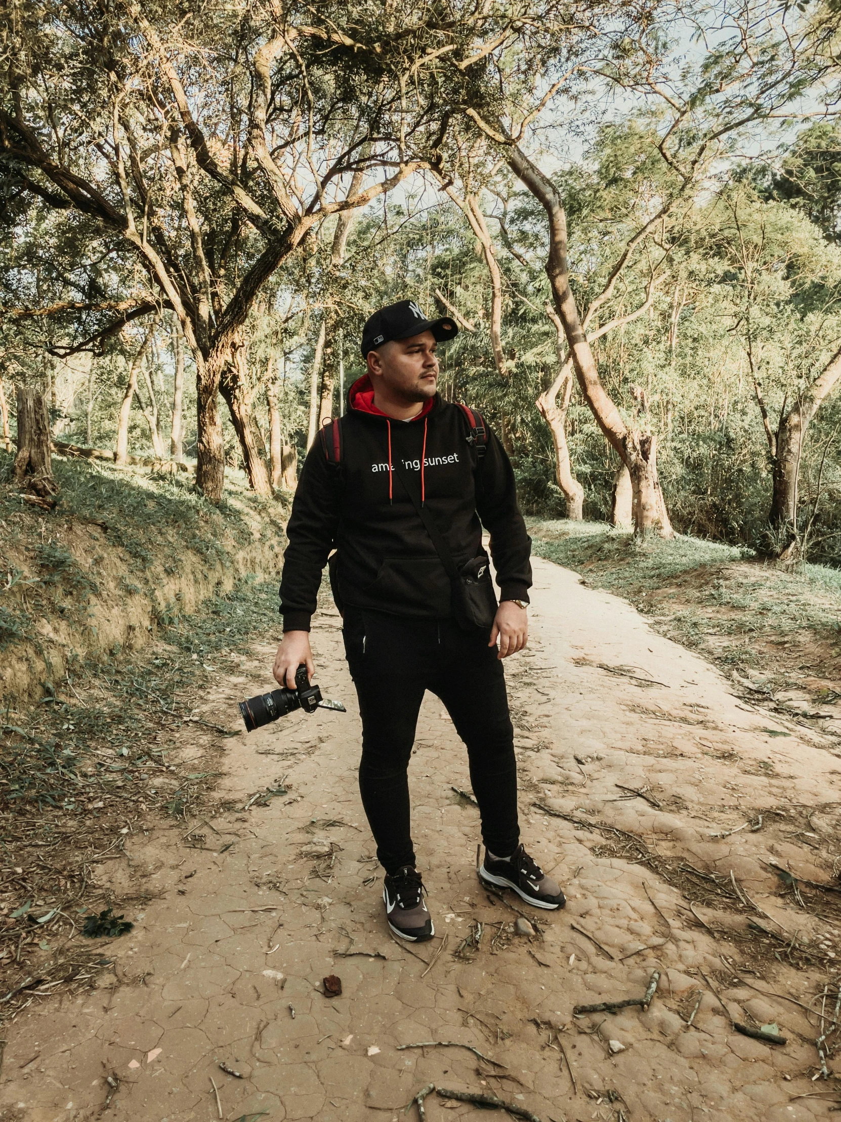 a man with a black and red jacket is standing in the dirt