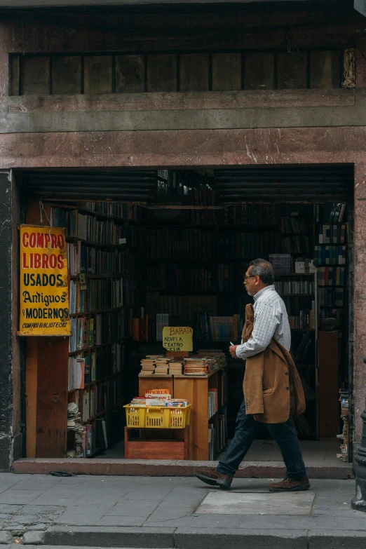 a man is walking in front of a book store