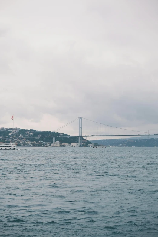 a bridge is seen over the water by the shore