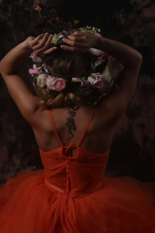 a woman wearing an orange dress and flowers in her hair