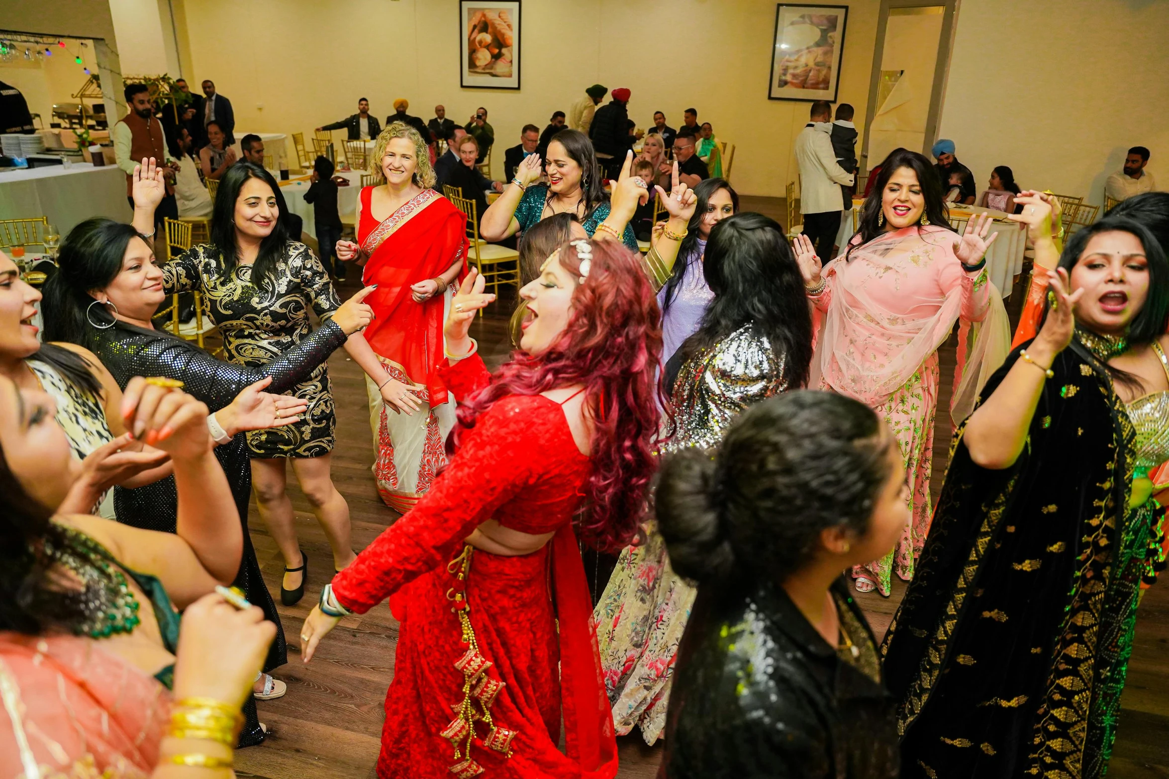 many young women are wearing red and gold indian outfits