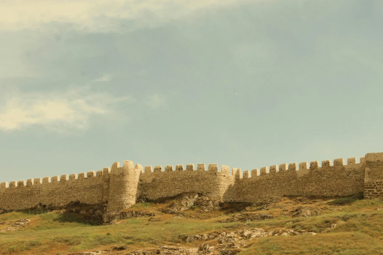 the stone walls of a defensive castle are all lined up against the grass