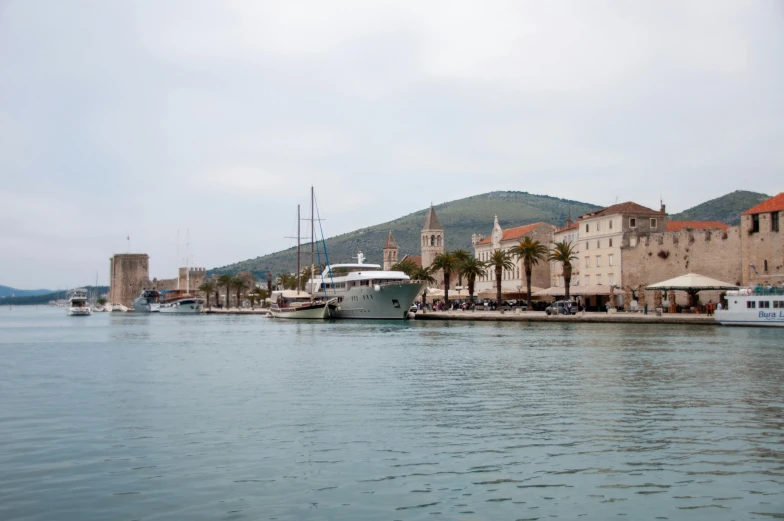 many boats are docked along the shore by buildings