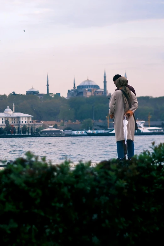 a man and woman standing next to water