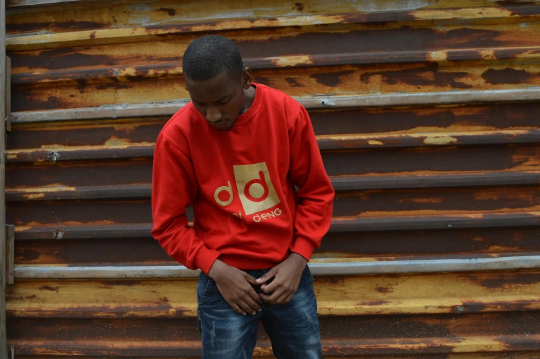 a black man is standing in front of rusted metal