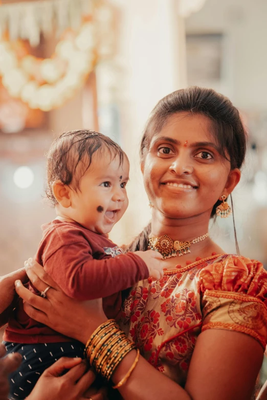 a woman in an orange top holding a toddler