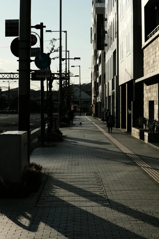 a long road with no cars on it near tall buildings